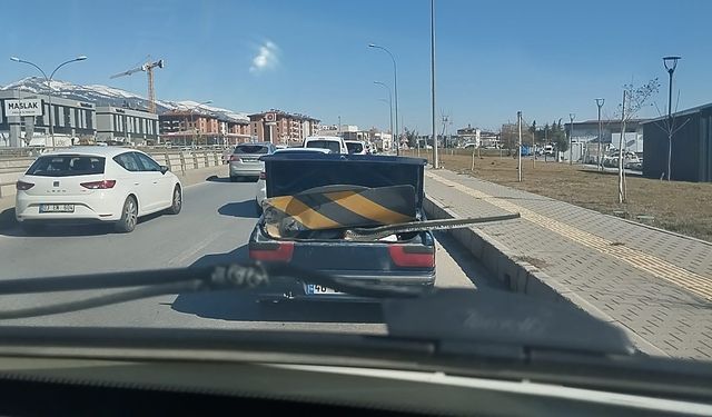 Karayolu işaret levhasını otomobil ile taşıdı